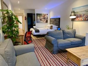 a living room with a couch and a bed at The Waterfront Lodges in Coventry