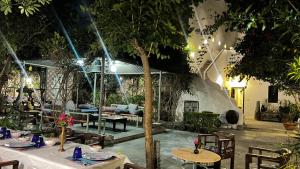 a patio with tables and chairs and a fireplace at Mosaics Guest House in Jaipur