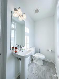 a white bathroom with a sink and a toilet at Keppel Circle Residence in Brampton +58 photos