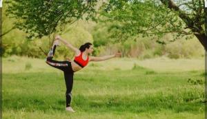 a woman doing a yoga pose in a field at Rifugio Felice in Bagnolo Piemonte