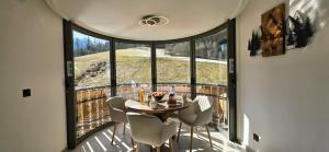 a room with a table and chairs and a large window at Les Chalets d'Offaz - Centre Abondance - Alp'in C in Abondance
