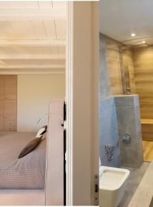 a bedroom with a bed and a sink and a toilet at Paros Tranquility Villa in Dhragoulás