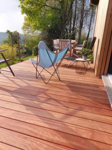 a chair and a table on a wooden deck at Aux Capucines in Theux