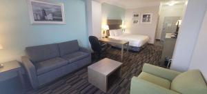 a hotel room with a couch and a bed at Kemah Edgewater Hotel, SureStay Collection by Best Western in Seabrook +13 photos