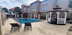 a gazebo and chairs next to a swimming pool at Kemah Edgewater Hotel, SureStay Collection by Best Western in Seabrook