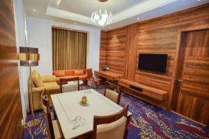a living room with a dining table and a television at Best Western Vrindavan in Vrindāvan