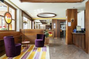 a lobby with purple chairs and a table at Best Western Hotel Nevada in San Vito di Cadore