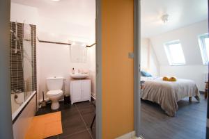 a bathroom with a toilet and a sink and a bed at Le Cocon I Hyper Centre & Calme in Crozon +11 photos
