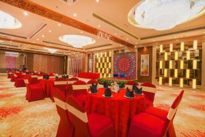 a banquet hall with red tables and red chairs at Best Western Plus Chandigarh Mohali in Mohali
