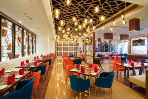 a restaurant with tables and chairs with red chairs at Best Western Plus Chandigarh Mohali in Mohali