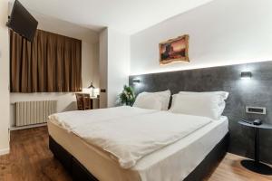 a bedroom with a large white bed in a room at Best Western Hotel Nevada in San Vito di Cadore +122 photos