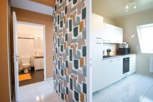 a kitchen with a wall covered in colorful tiles at Le Cocon I Hyper Centre & Calme in Crozon