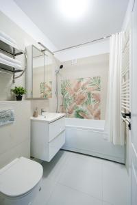 a white bathroom with a toilet and a sink at Smile Apartments in Bucharest +204 photos