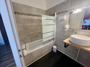 a bathroom with a sink and a shower at Logis Hôtel de la Bruyere in Pouzauges +22 photos