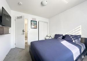 a bedroom with a blue bed and a television at Keppel Circle Residence in Brampton
