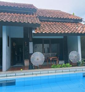 a house with a swimming pool in front of it at Palagan Boutique Hotel in Ngaglik