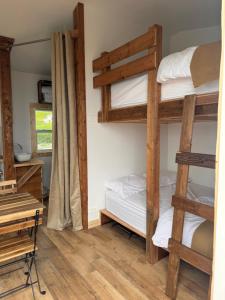 a room with two bunk beds and a desk at Les Cabanes du Cap in Miquelon