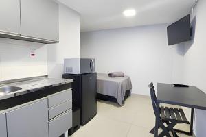 a kitchen with a sink and a bed in a room at Studio VI - Com Ar Condicionado in Jundiaí
