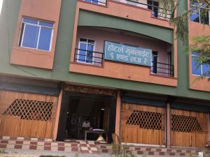 a building with a sign on the side of it at Hotel Moonlight and Lodge in Birtamod
