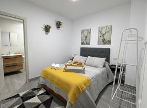 a bedroom with a bed with a yellow blanket at El nido in Villarcayo