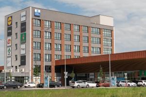a large building with cars parked in a parking lot at Best Western Hotel Presov in Prešov