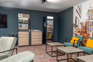 a living room with blue walls and chairs and tables at Best Western Hotel Presov in Prešov