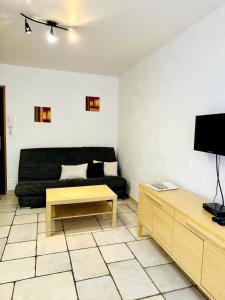 a living room with a black couch and a coffee table at "L'olivier" - Résidence Rive Gauche in Les Salles-sur-Verdon