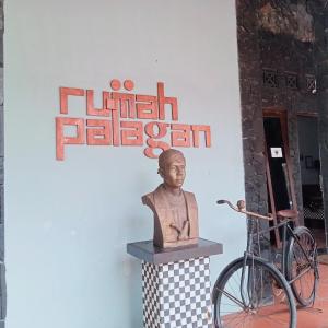 a statue of a head on a pedestal next to a bike at Palagan Boutique Hotel in Ngaglik