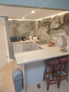 a kitchen with a counter and two stools at Tramway Apartment in Blessington