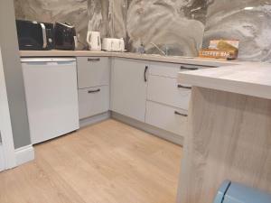 a kitchen with white cabinets and a sink at Tramway Apartment in Blessington +8 photos