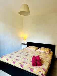 a bedroom with a bed with pink slippers on it at "L'olivier" - Résidence Rive Gauche in Les Salles-sur-Verdon