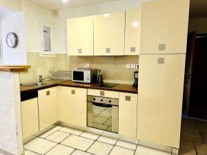 a kitchen with white cabinets and a microwave at "L'olivier" - Résidence Rive Gauche in Les Salles-sur-Verdon +9 photos