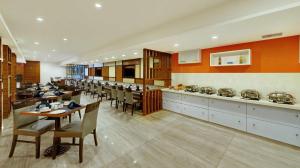 a large dining room with tables and chairs and counters at Best Western Alkapuri, Vadodara in Vadodara