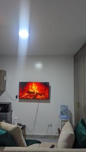 a tv hanging on a wall in a living room at Imperial cabins in Nyeri