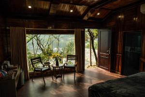 a bedroom with a table and chairs and a window at Bản Mận Retreat in Sapa