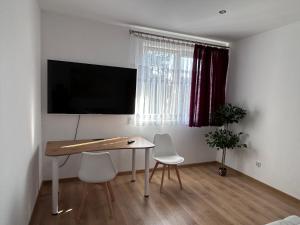 a room with a table and two chairs and a television at Pod LIPÓWKAMI in Olsztyn