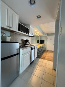 a large kitchen with white cabinets and a tile floor at Wild Dunes Inn in Ocean City