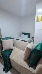 a living room with a couch with green pillows at Imperial cabins in Nyeri