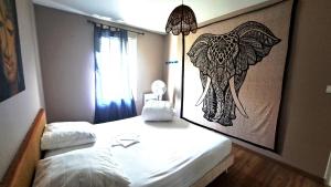 a bedroom with a picture of an elephant on the wall at TURQUOISE in Linxe +19 photos
