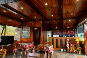 a room with tables and chairs and a flat screen tv at Bản Mận Retreat in Sapa