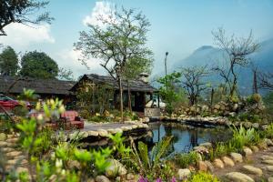 a house with a pond in front of it at Bản Mận Retreat in Sapa