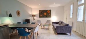 a living room with a couch and a table and chairs at HISTOIRE DE LOIRE - La Maison in Saumur