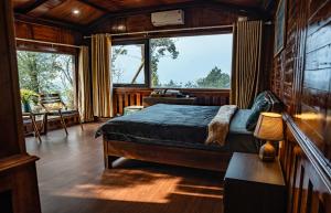 a bedroom with a bed and a large window at Bản Mận Retreat in Sapa