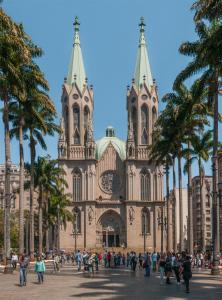 a large cathedral with palm trees in front of it at Center Plaza Hotel in São Paulo