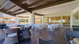 a restaurant with white chairs and tables and windows at Ashanti Aparthotel Wellness&Spa in Bibione