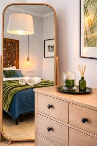 a bedroom with a bed and a mirror at Alta Luminara Boutique Residence Sea View Terraces Marbella Hills in Benahavís