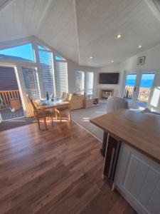 a large living room with a table and chairs at Bayview Luxury Lodge in Cockburnspath