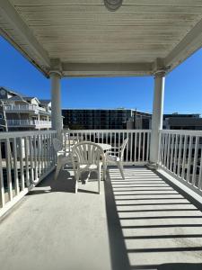 a porch with two chairs and a table on it at Ebb Tide Suites in Ocean City