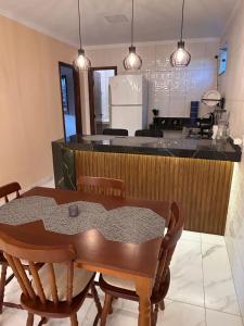 a dining room with a table and a kitchen at Refúgio do Mar in Ilhéus