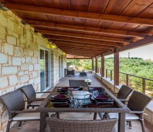 an outdoor dining table with chairs on a patio at Villa Chara Chania in Agia Marina Nea Kydonias